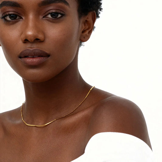 Woman wearing a gold necklace on a white background