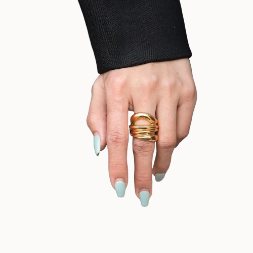 Hand wearing a gold ring with a plain background