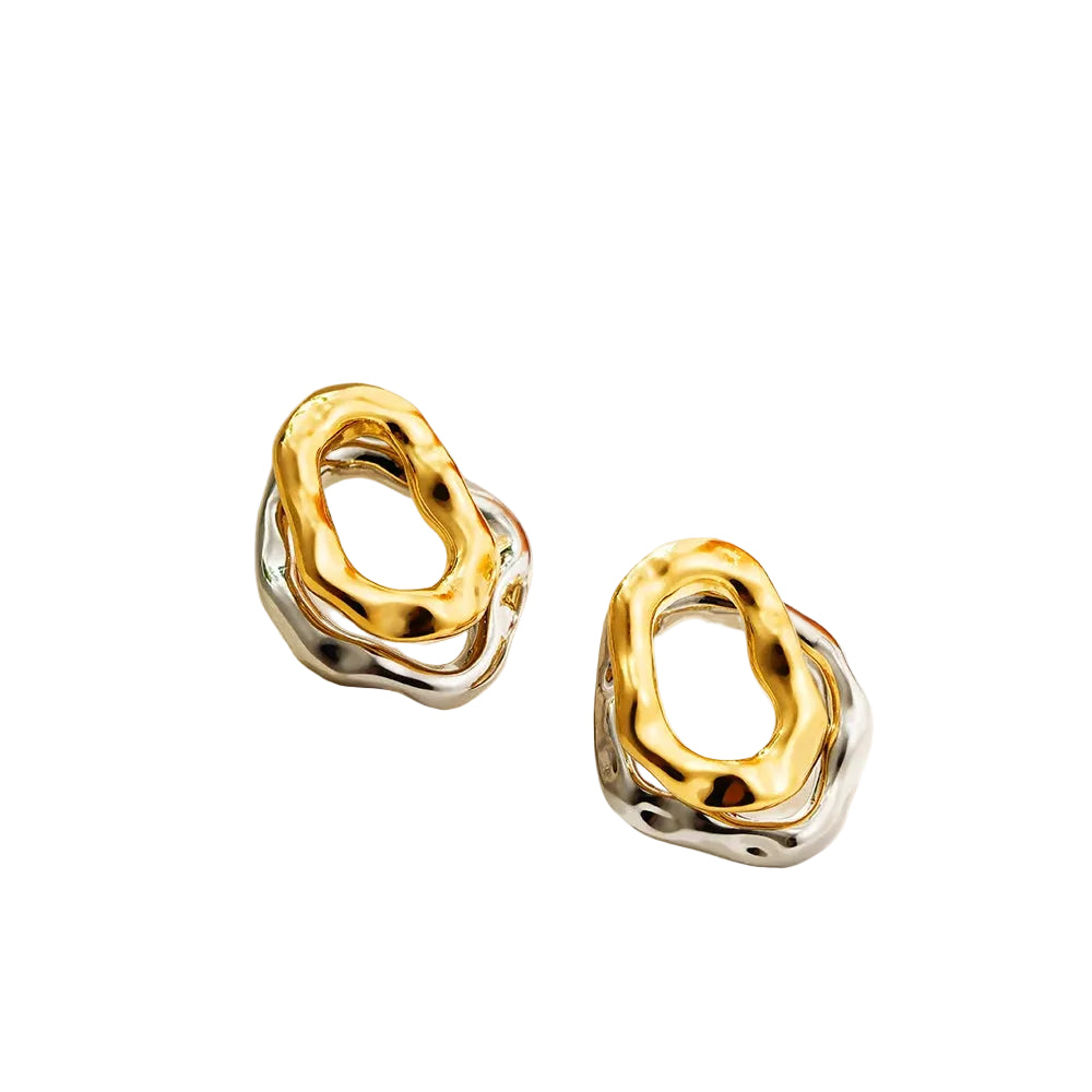 Gold and silver earrings on a light background