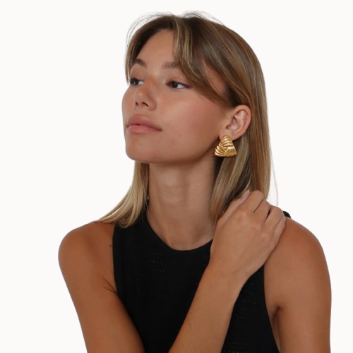 Woman wearing gold earrings on a white background
