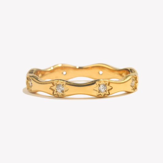 Gold ring with diamond accents on a white background