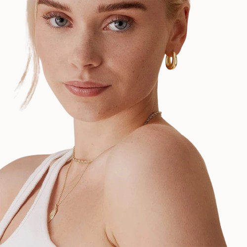 Woman wearing gold jewelry on a white background