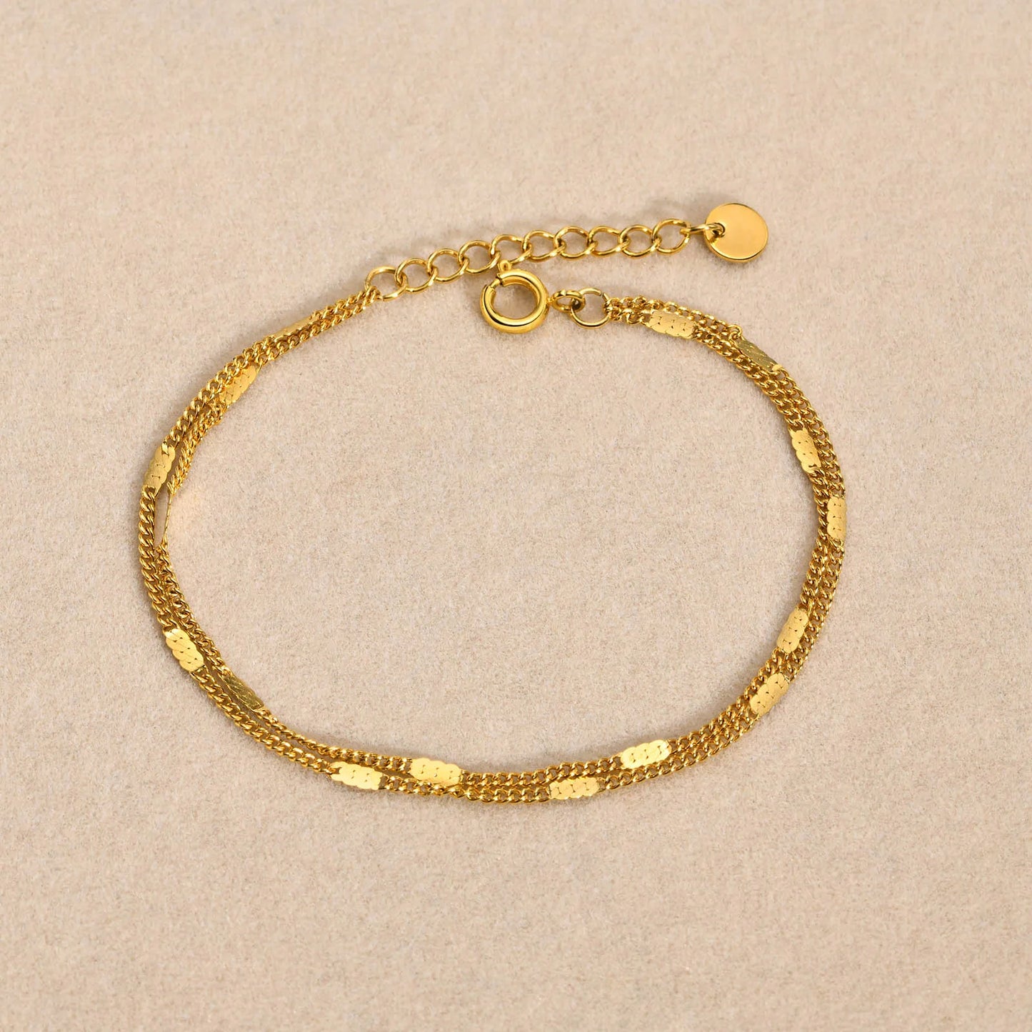 Gold bracelet on a beige background