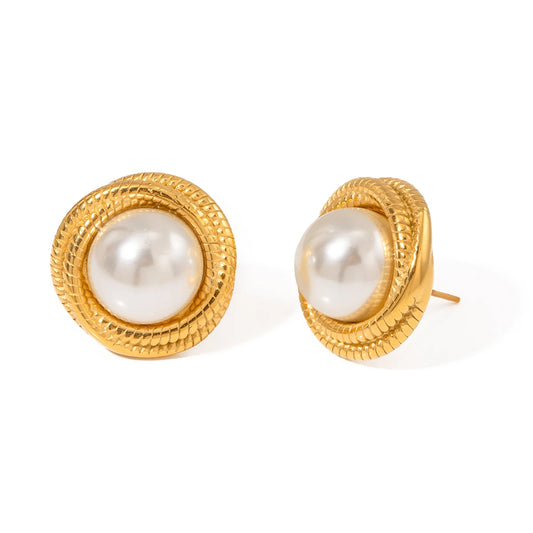 Gold earrings with pearl centers on a white background